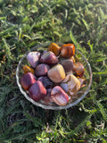 Mookaite Jasper tumbled stone with red, gold, cream, and brown coloring