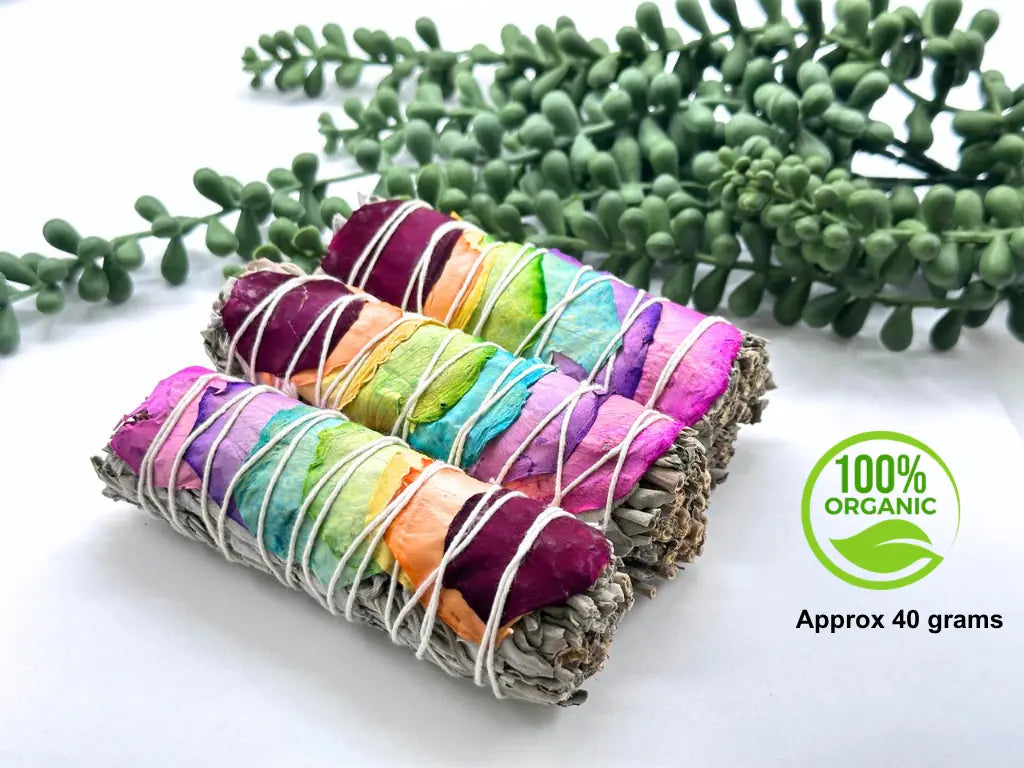 Close-up of organic white sage and colorful chakra rose petals representing the seven chakras