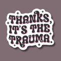 Sticker with text 'THANKS, IT'S THE TRAUMA' on a dark background