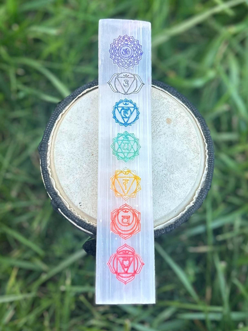 Selenite chakra charging plate with seven colorful chakra symbols