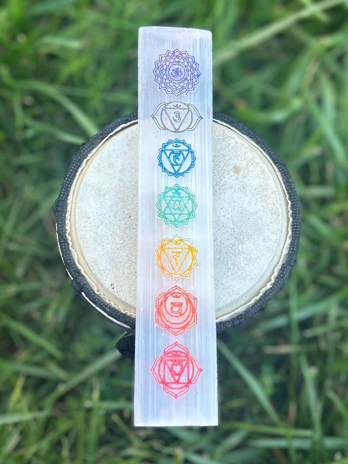Selenite chakra charging plate with seven colorful chakra symbols