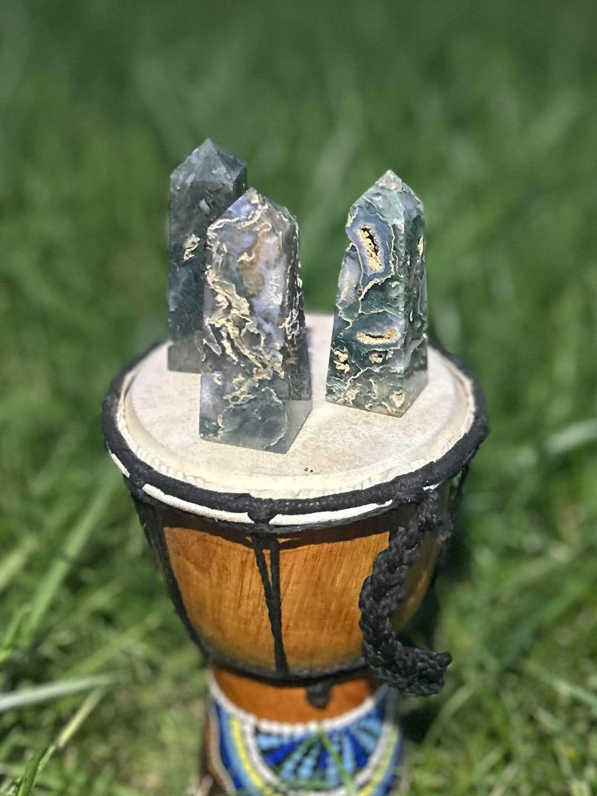 Three natural Moss Agate crystal towers showing unique green patterning and crystalline pockets