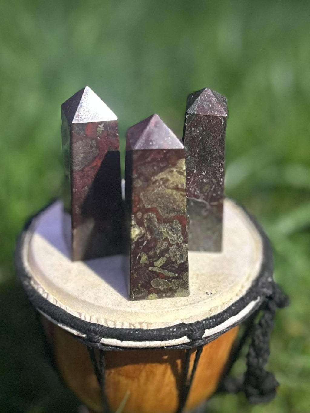 Close-up of Dragon Blood Jasper crystal towers with polished points and earthy red and green coloring