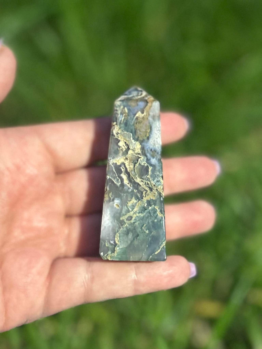 Moss Agate crystal tower held in hand showing green natural patterning, inclusions and size