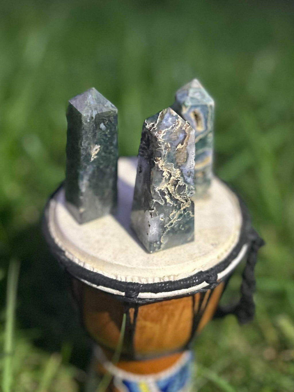 Close-up of polished Moss Agate towers showing natural inclusions, earthy patterns and translucent areas