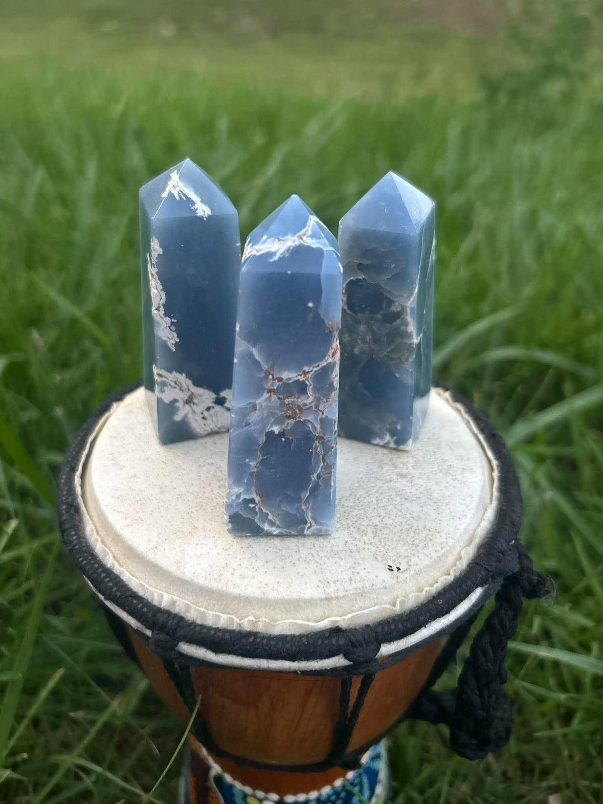 Close-up of three polished Angelite crystal towers with unique natural blue and white patterns