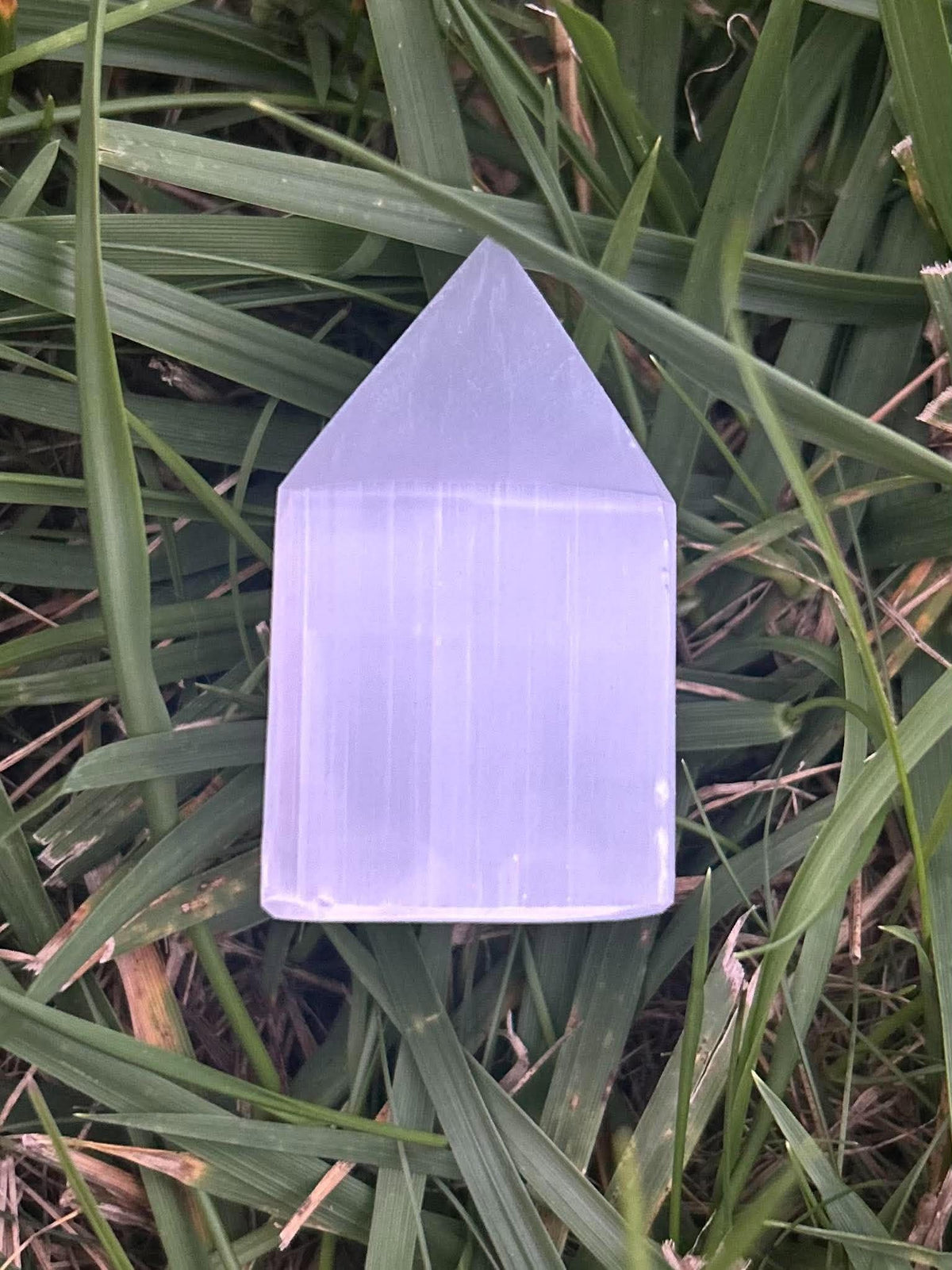 Selenite crystal tower showing natural white striations and polished point