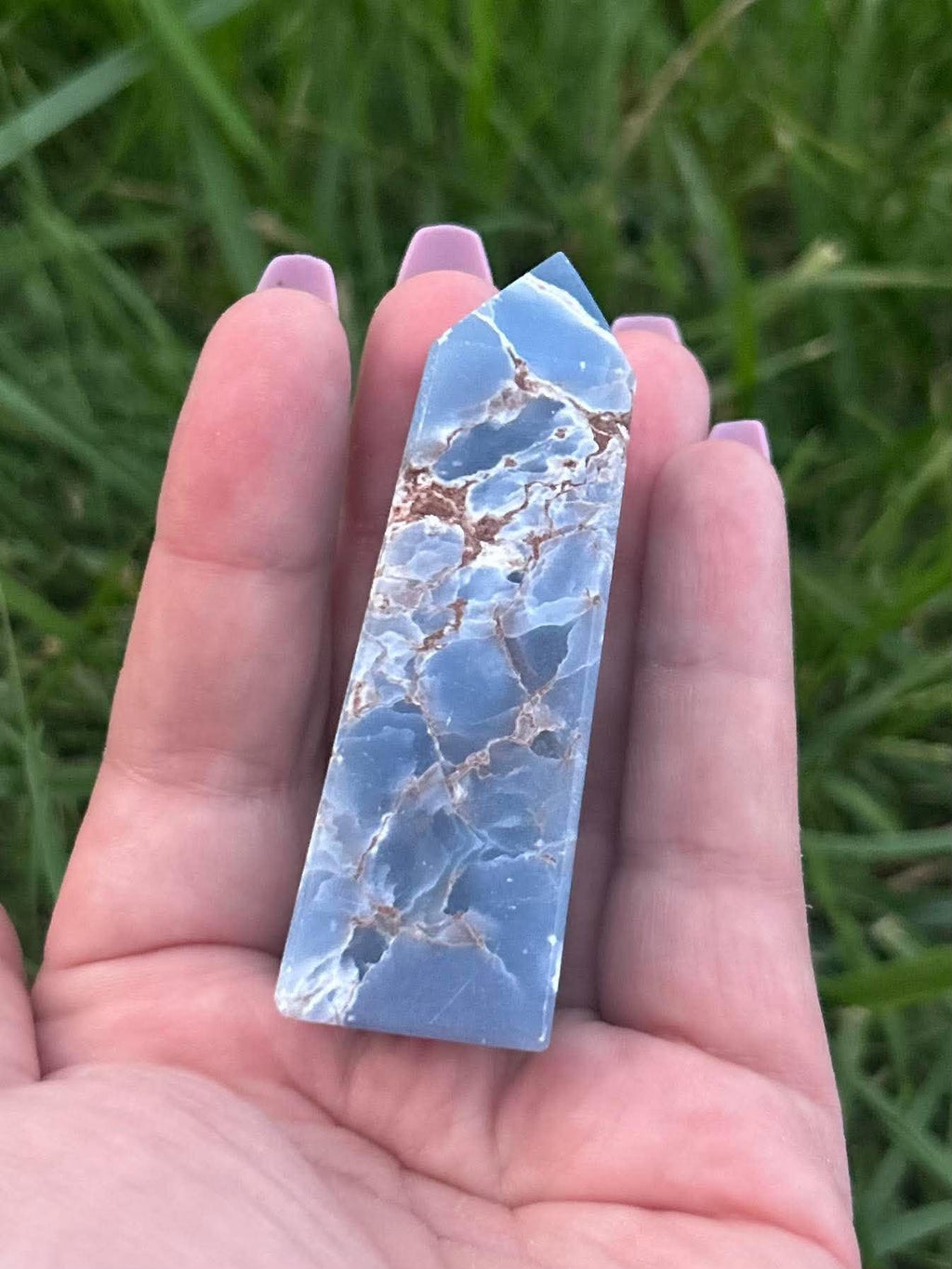 Polished blue Angelite crystal tower showing natural matrix and pointed crystal shape