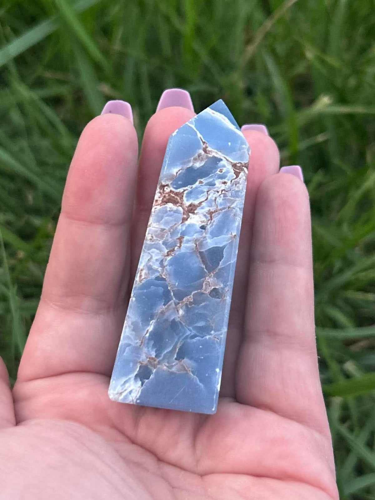 Polished blue Angelite crystal tower showing natural matrix and pointed crystal shape
