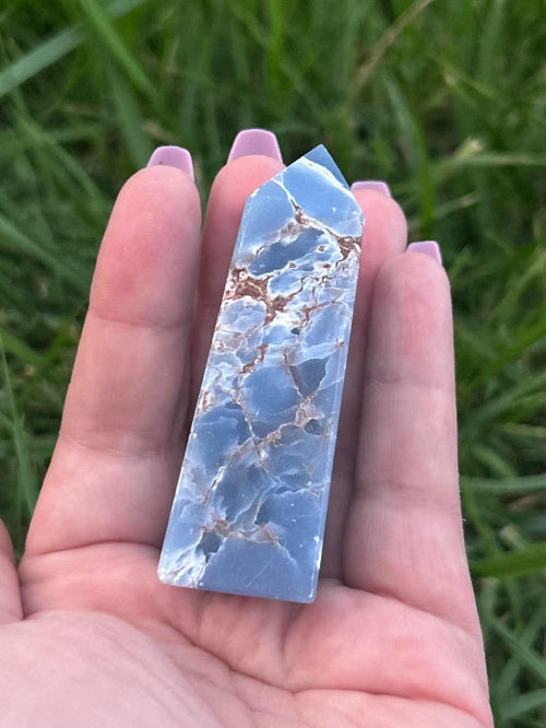 Polished blue Angelite crystal tower showing natural matrix and pointed crystal shape