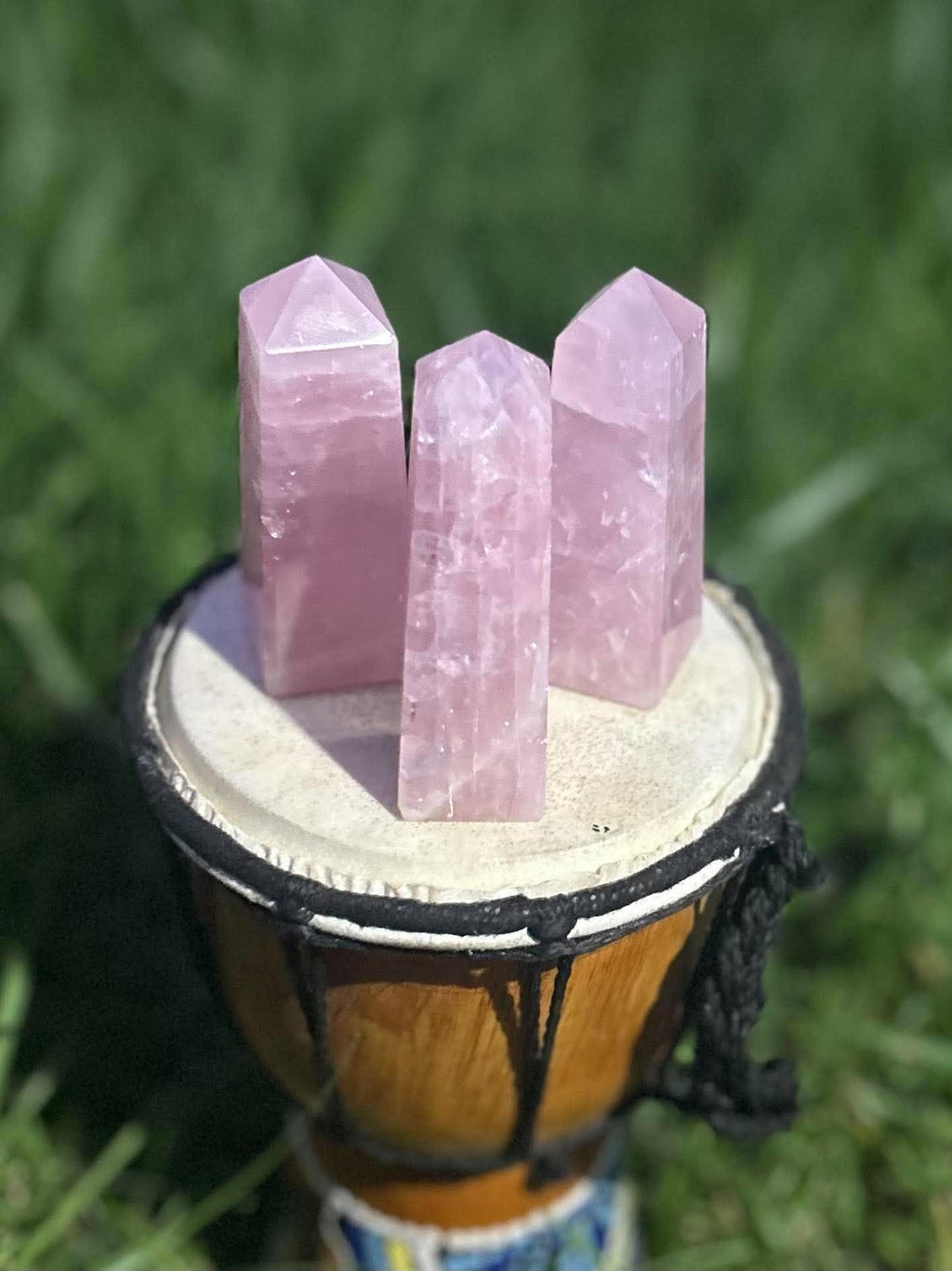 Three pink Rose Quartz crystal towers showing natural inclusions and variations in sunlight