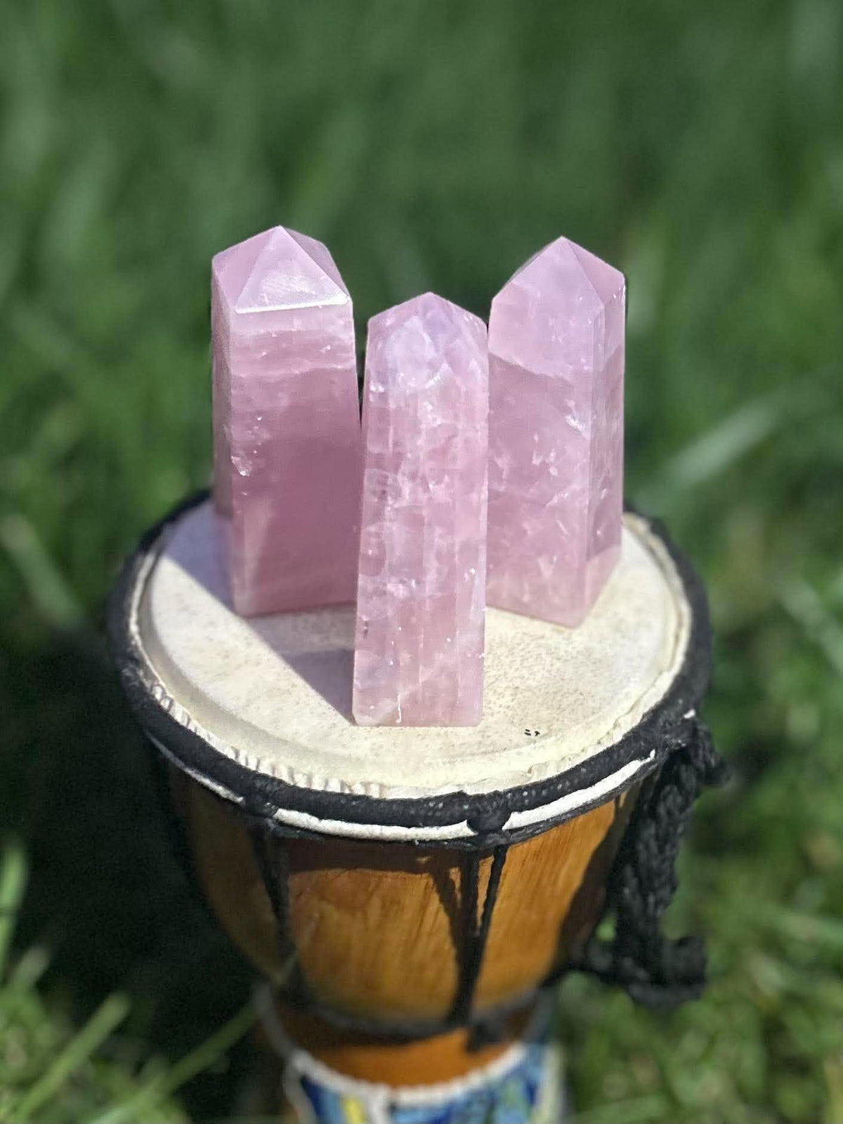 Three pink Rose Quartz crystal towers showing natural inclusions and variations in sunlight