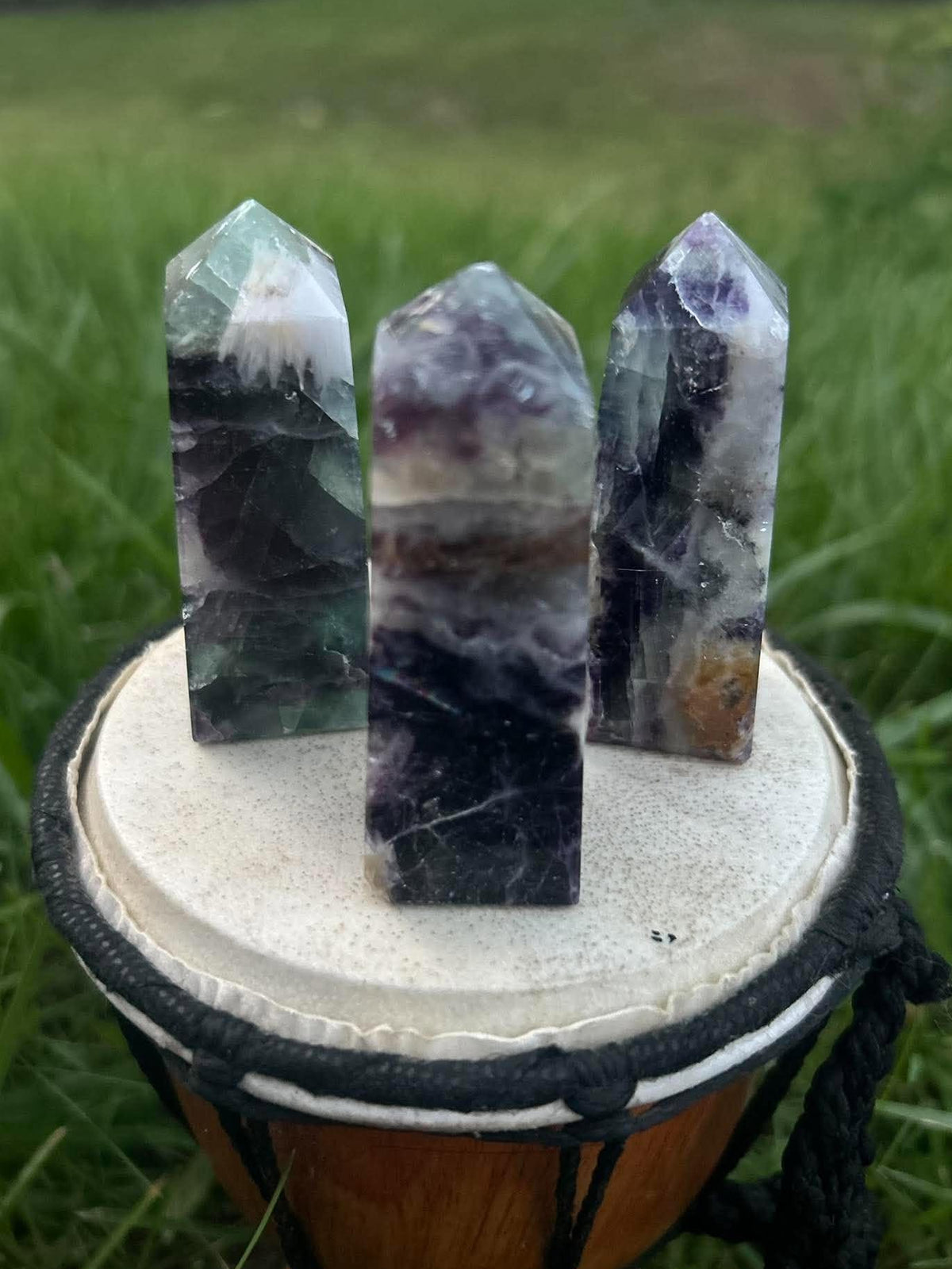 Three polished Rainbow Fluorite towers showing unique green, purple and translucent color variations
