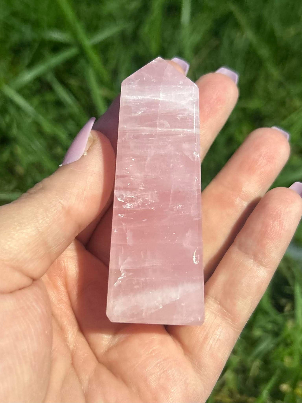Rose Quartz crystal tower held in hand outdoors showing size, translucent pink color and natural inclusions