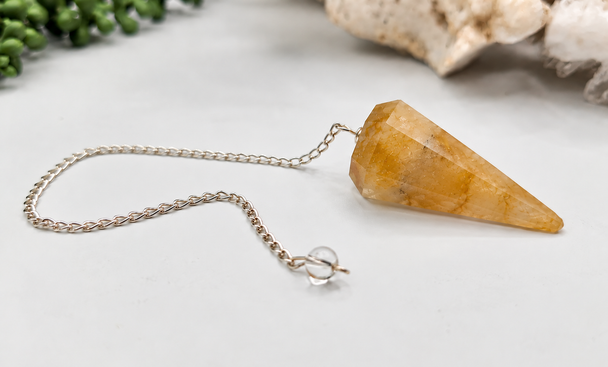 Golden Healer crystal pendulum showing natural golden yellow coloring and faceted quartz point