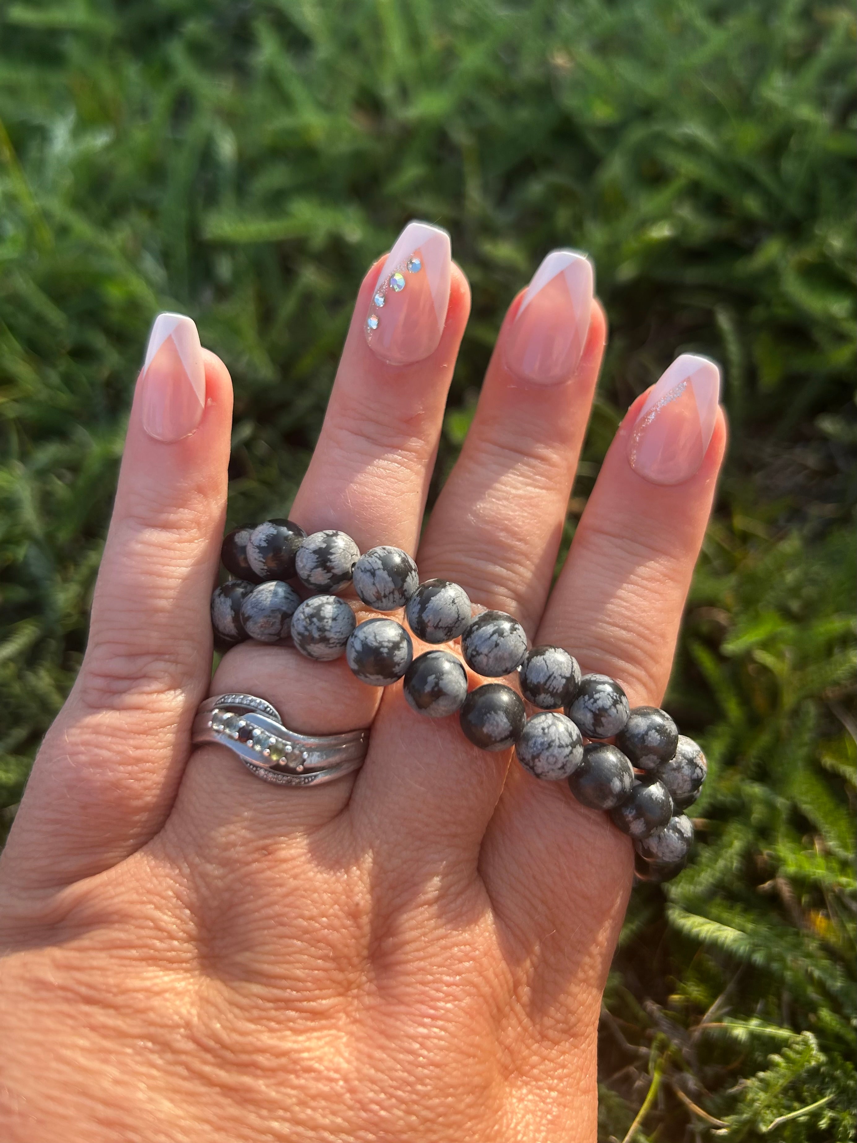 Close-up of polished Snowflake Obsidian beads with natural gray and white patterns