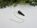 Polished Hematite crystal pendulum with silver-plated chain for divination and grounding practices
