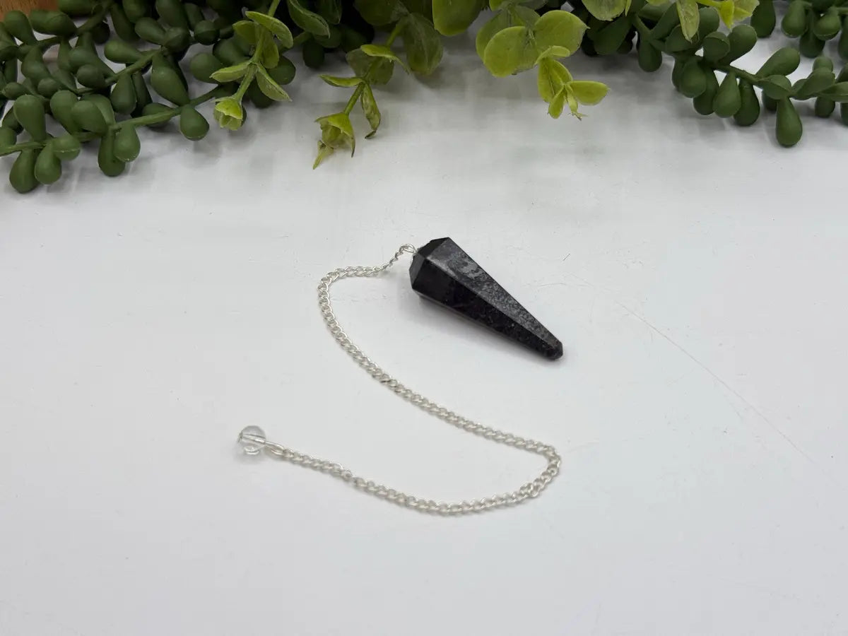 Polished Hematite crystal pendulum with silver-plated chain for divination and grounding practices