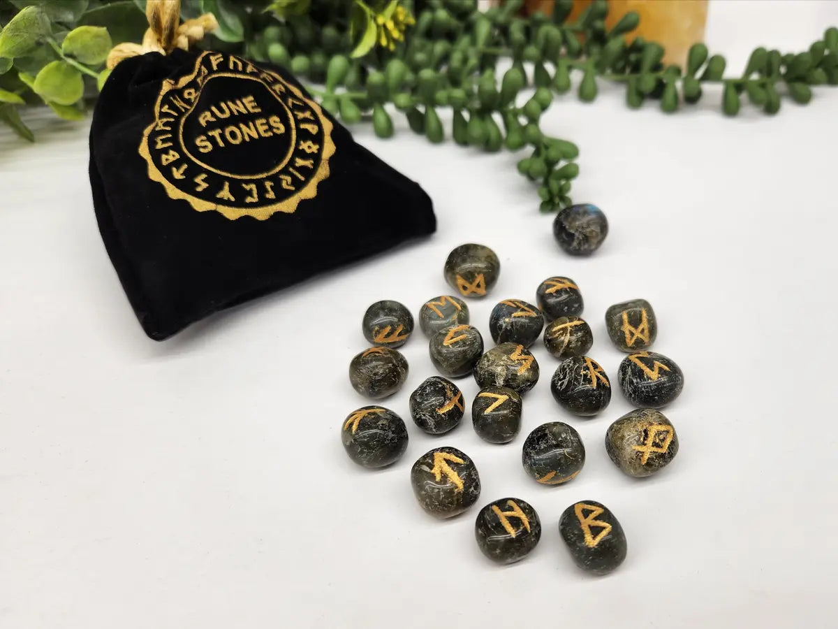 Labradorite Elder Futhark rune stone set with gold engraved symbols and black storage pouch