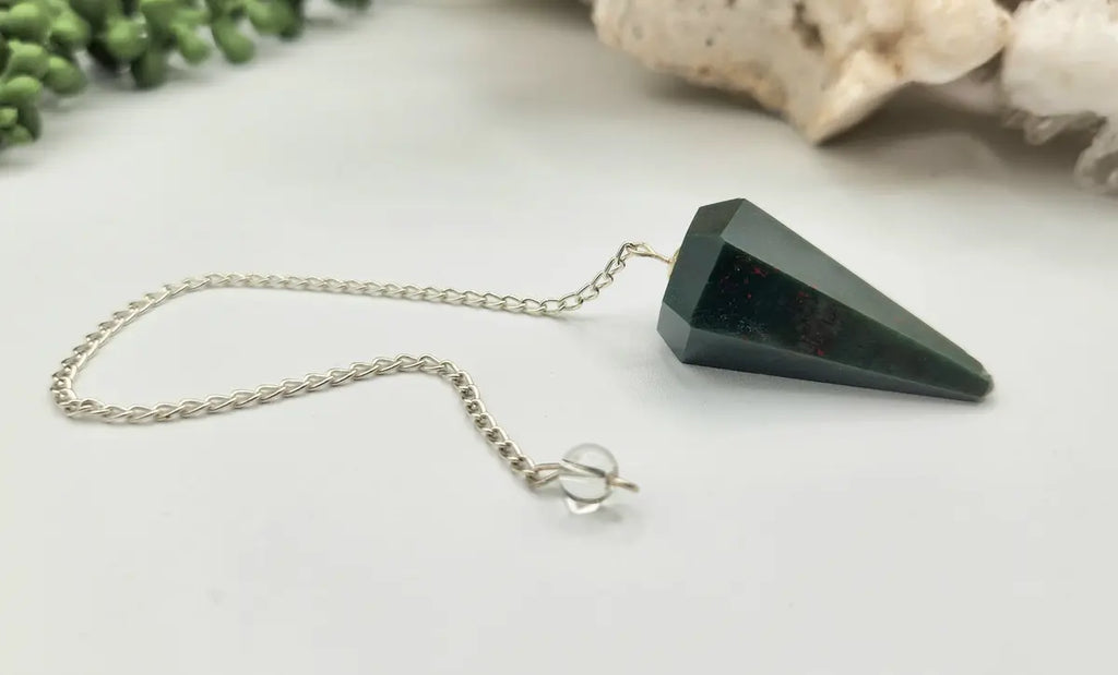 Natural Bloodstone pendulum showing deep green coloring and natural red inclusions with faceted crystal point