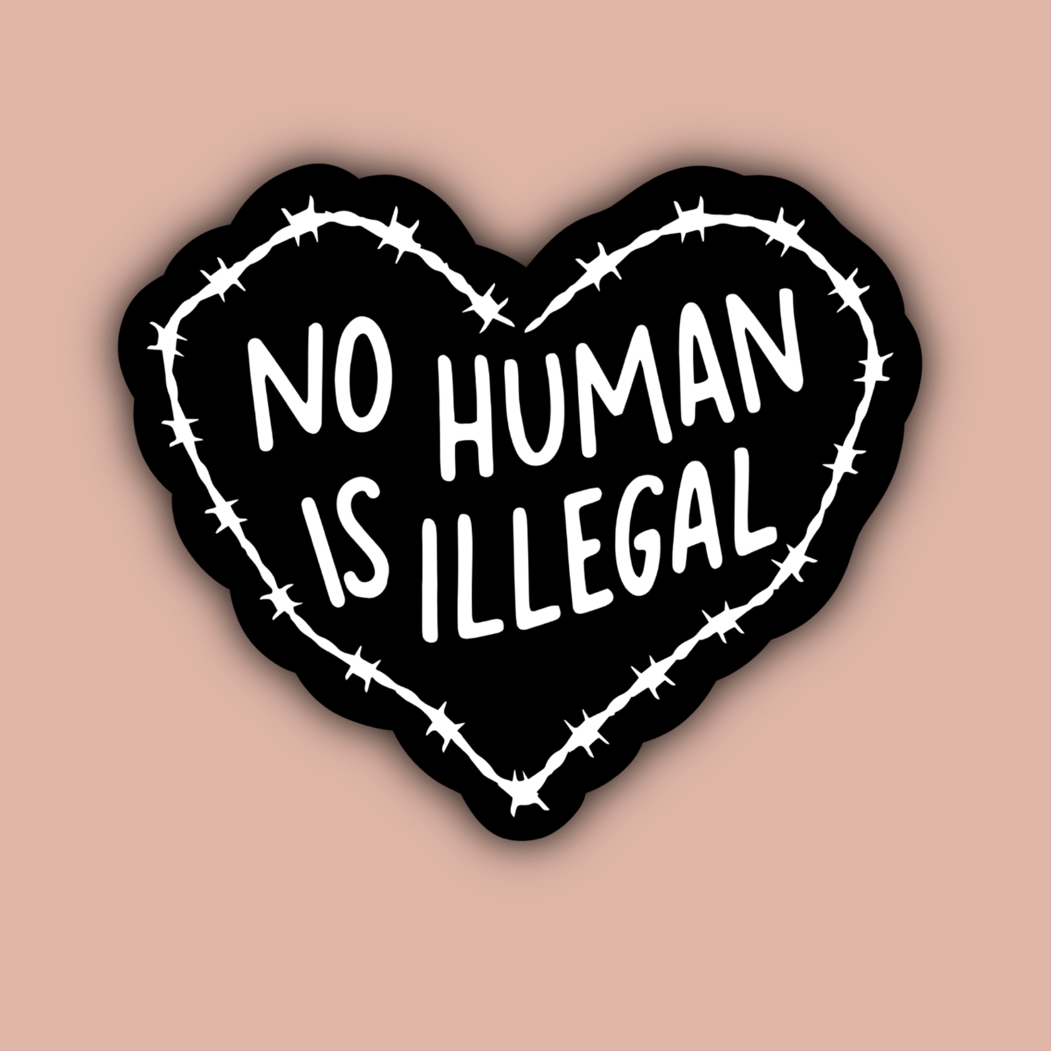 Heart-shaped sticker with 'No Human Is Illegal' text on a pink background